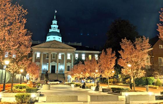 Maryland State House at night with blossoming trees and construction