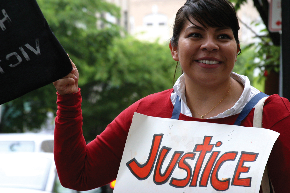 A young woman holding a saign that says justice