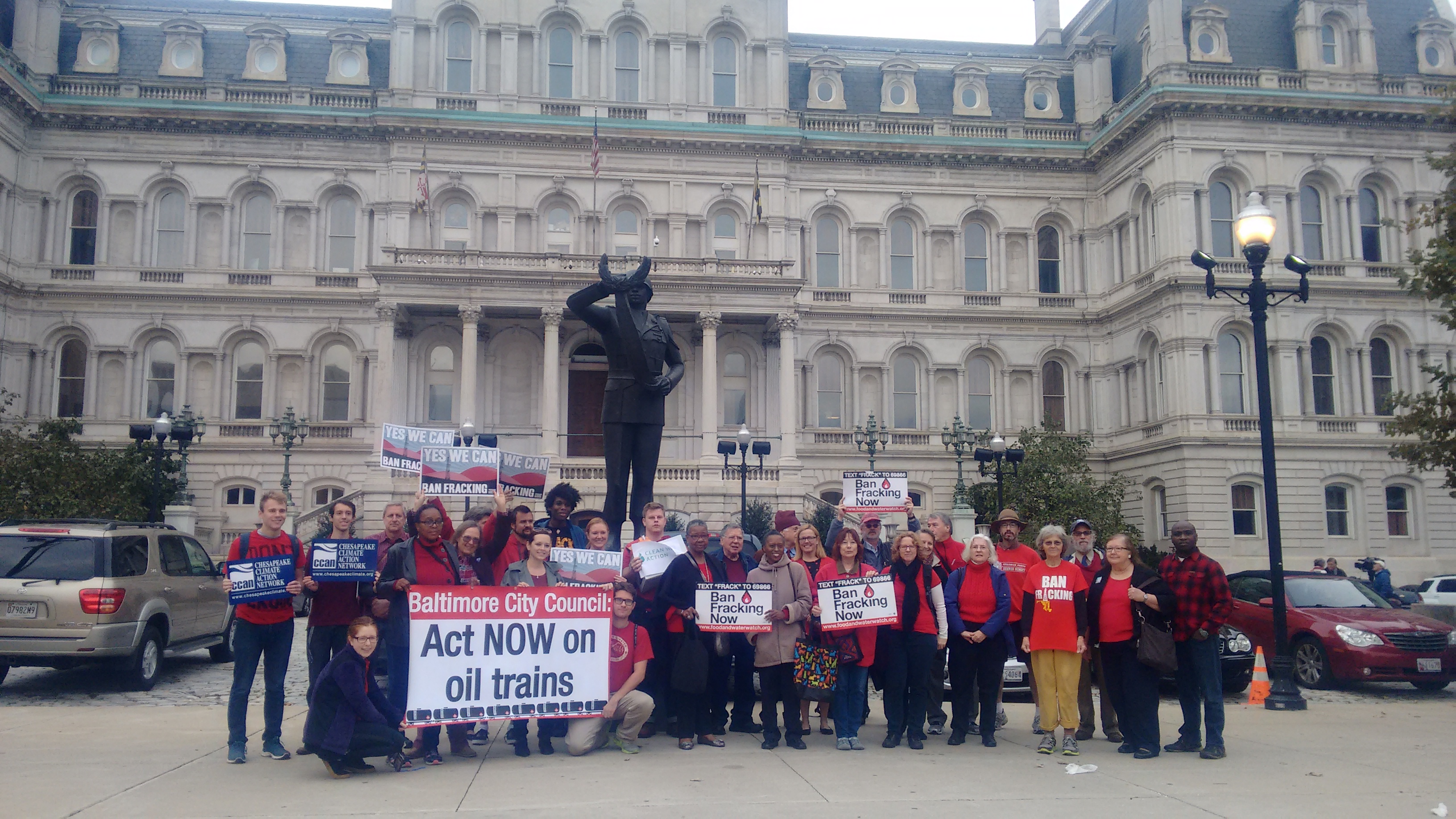 Over 30 Baltimore residents outside of City Hall wearing red in support of the Oil Trains Ordinance and the Fracking Ban